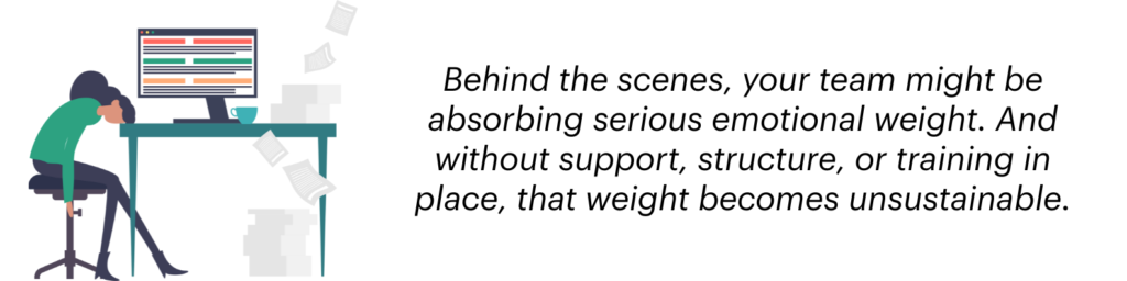 An image showing a woman slumped over her desk in frustration because she has to manage her charity's social media channels 